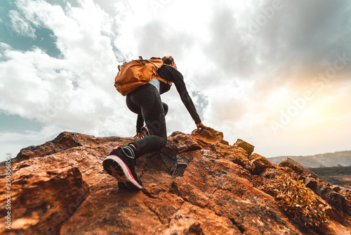 Fototapeta Naklejka Na Ścianę i Meble -  Success woman hiker hiking on sunrise mountain peak - Young woman with backpack rise to the mountain top. Discovery Travel Destination Concept