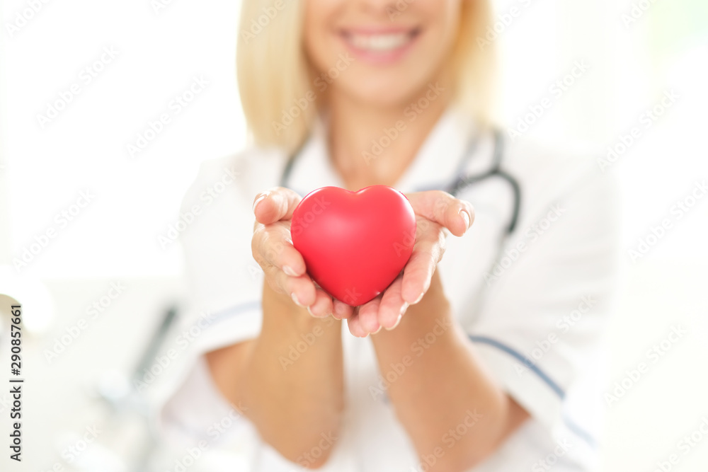 No visible female doctor i holding a heart shape. No visible female doctor i holding a heart shape.