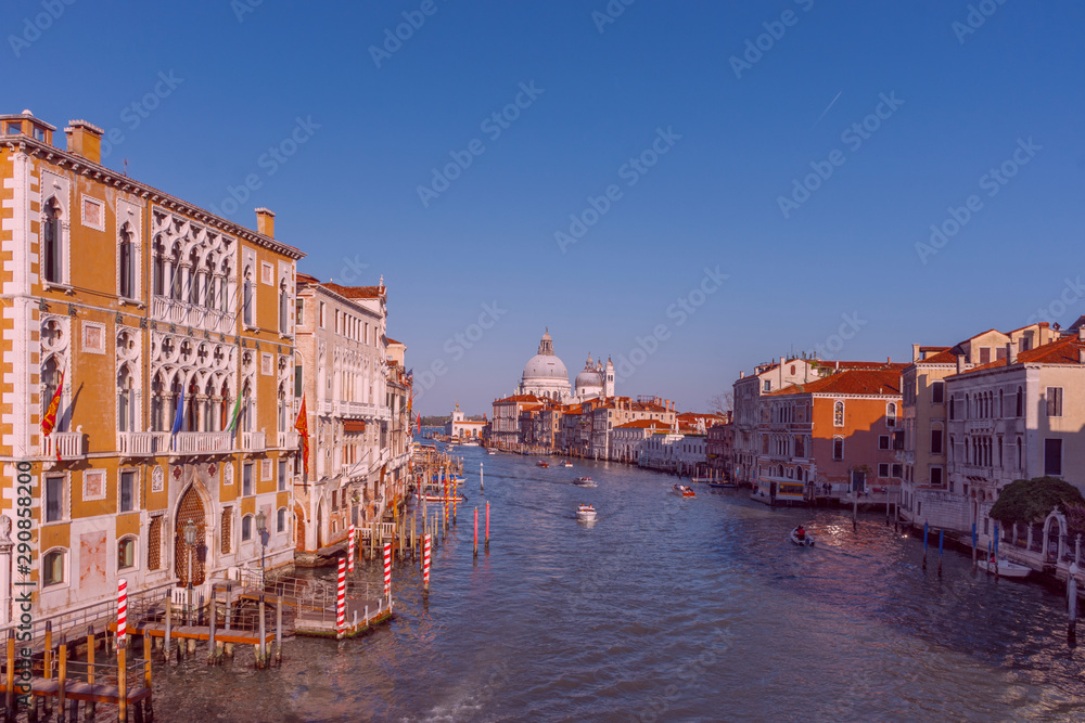Beautiful Venetian view with boats on Grand Canal and Basilica Santa Maria della Salute, in Venice, Italy.