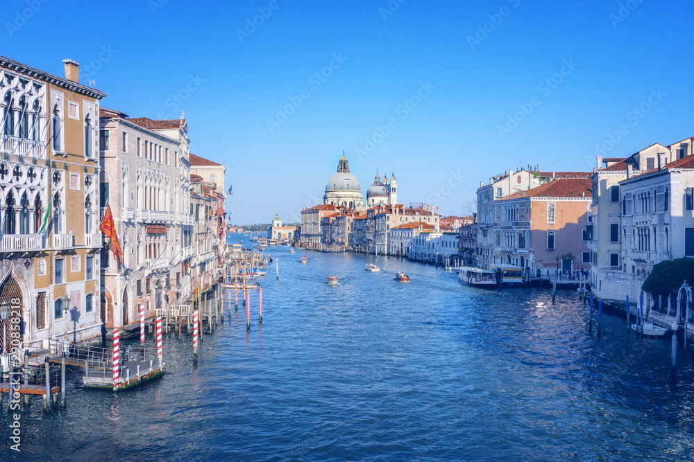 Beautiful Venetian view with boats on Grand Canal and Basilica Santa Maria della Salute, in Venice, Italy, in pastel colors.