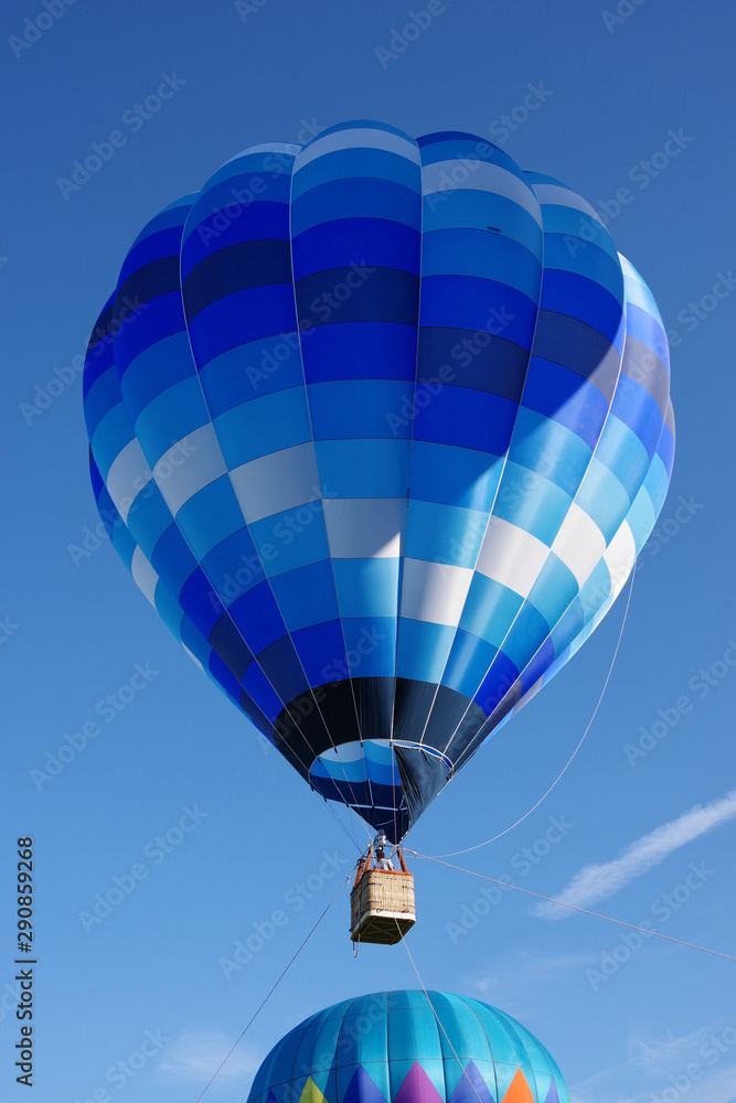 Naklejka premium Two hot air balloons flying up into the sky on a bright summer morning