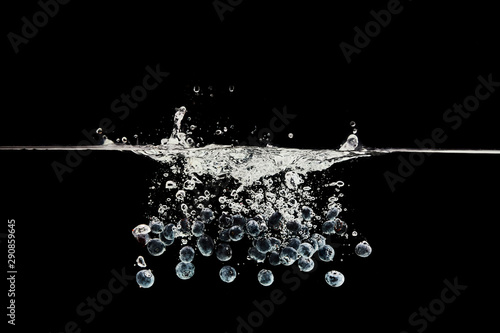 fresh blueberries falling in water with splash isolated on black