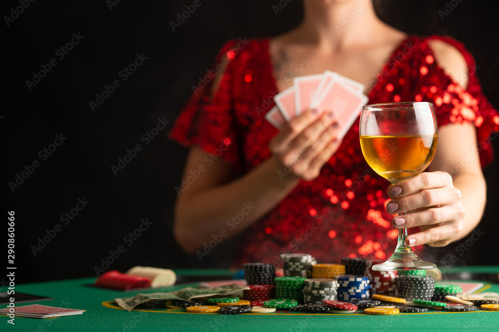 The girl won everything and takes all the chips, playing in a casino, poker. Accent and focus on a glass of wine. The girl won everything and takes all the chips, playing in a casino, poker. Accent and focus on a glass of wine.