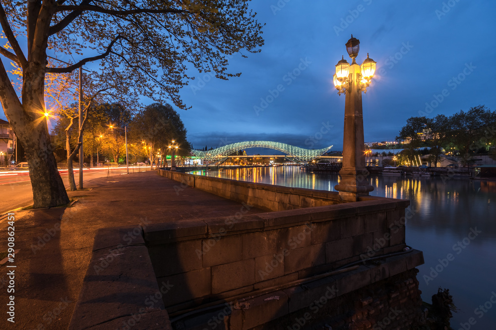 Fototapeta premium Night view of Peace Bridge and Kura embankment in Tbilisi