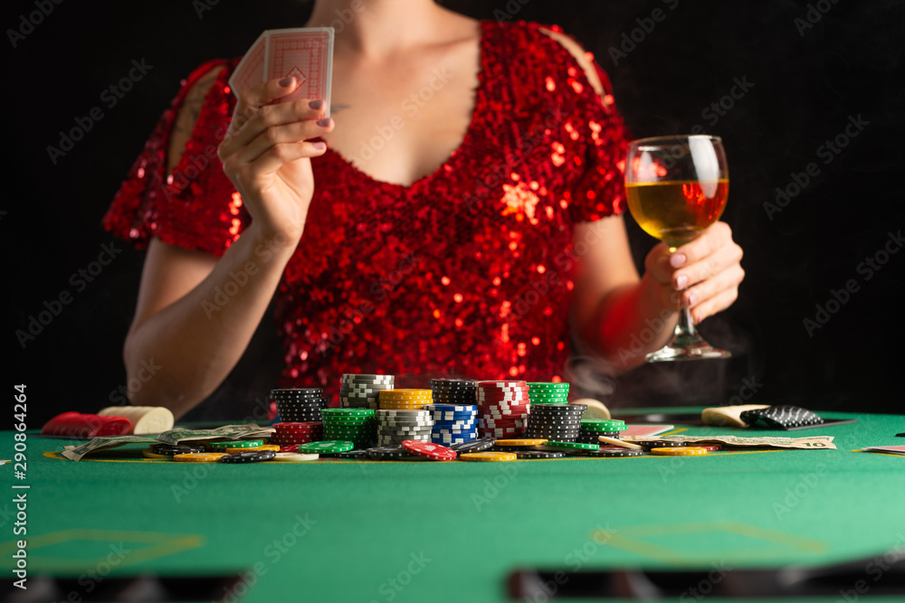 girl in evening dress plays poker in a casino. focus on the card and focus girl in evening dress plays poker in a casino. focus on the card and focus