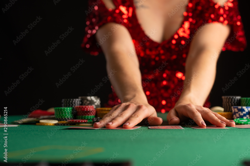 girl in evening dress plays poker in a casino. focus on the card and focus girl in evening dress plays poker in a casino. focus on the card and focus