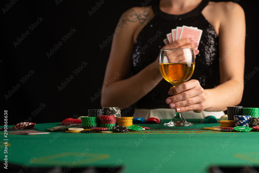 The girl won everything and takes all the chips, playing in a casino, poker. Accent and focus on a glass of wine. The girl won everything and takes all the chips, playing in a casino, poker. Accent and focus on a glass of wine.