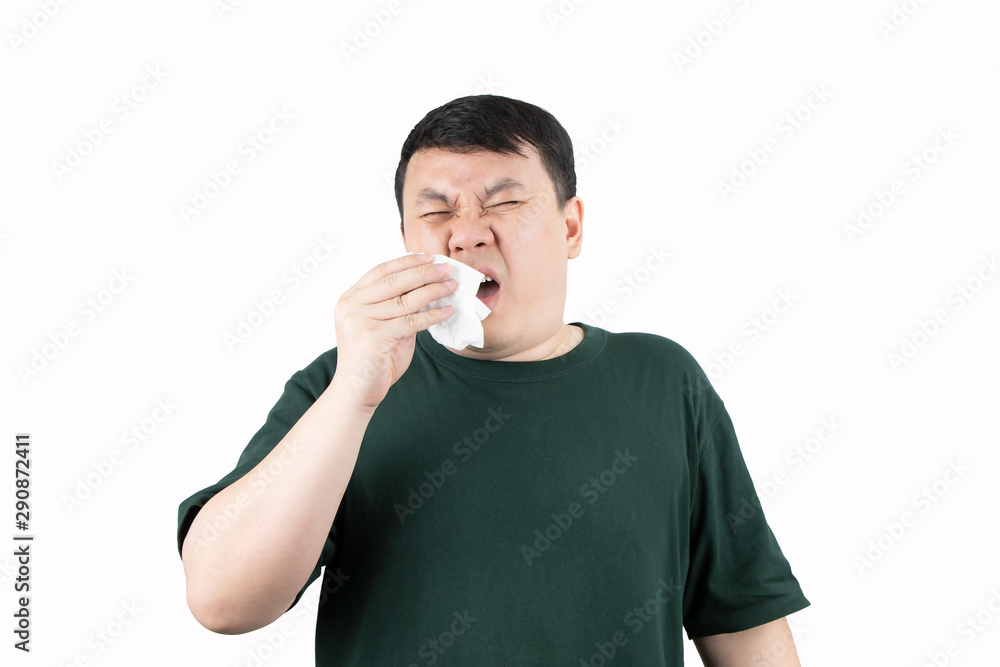 Portrait of young Asian man gets sick and blows his nose with napkin. Sneezing, cold, flu virus, illness disease, health care and treatment concept. Portrait of young Asian man gets sick and blows his nose with napkin. Sneezing, cold, flu virus, illness disease, health care and treatment concept.