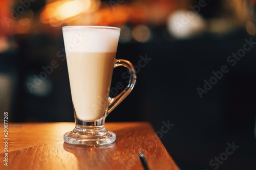 cup of coffee with cream on wooden background