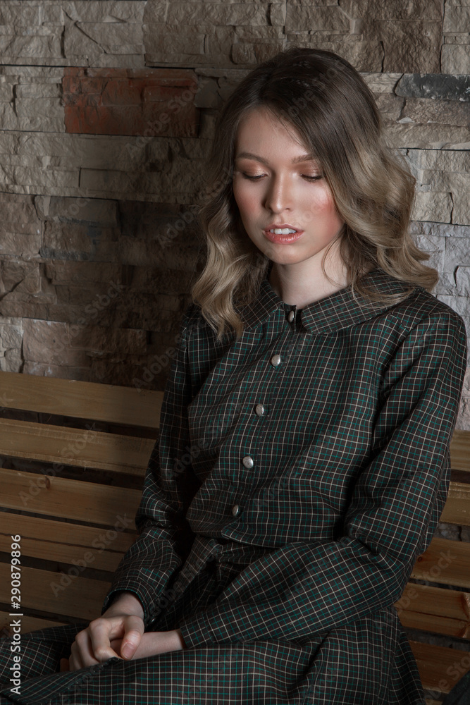 the concept of day rest, relaxation, thoughtfulness-the girl rests sitting on a chair. Calm expression of the woman's face, relaxed posture the concept of day rest, relaxation, thoughtfulness-the girl rests sitting on a chair. Calm expression of the woman's face, relaxed posture