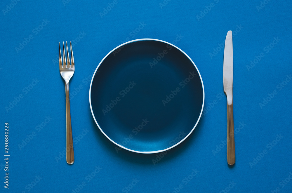 Plate fork and knife isolated on blue background. Plate fork and knife isolated on blue background.