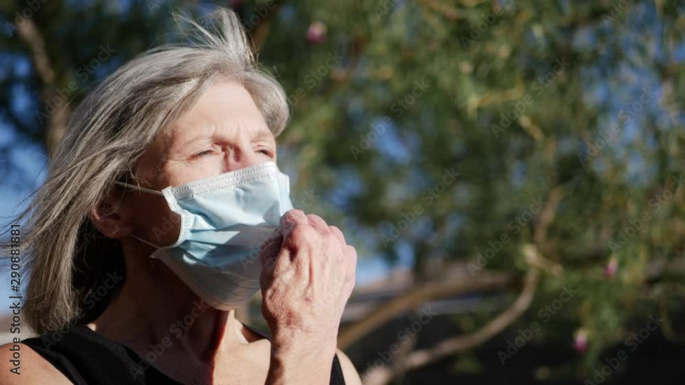 An aging elderly woman patient with a hospital mask breathing fresh air into her lungs after a treatment for her sickness. An aging elderly woman patient with a hospital mask breathing fresh air into her lungs after a treatment for her sickness.