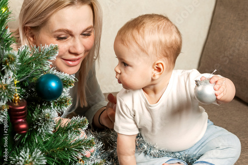 happy mother and her little daughter decorate the Christmas tree