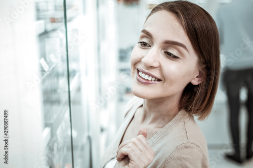 A smiling spouse deciding to buy extra vitamins while her husband at checkout. Free Download A smiling spouse deciding to buy extra vitamins while her husband at checkout. - GFXLoad