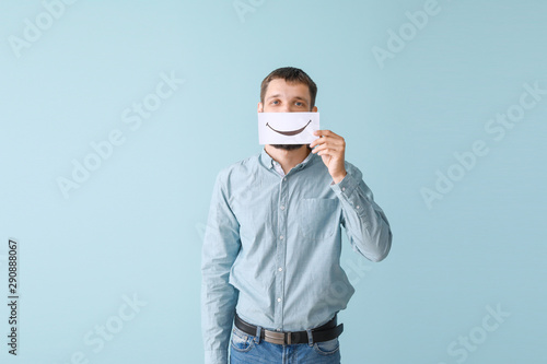 Man hiding mouth behind she...