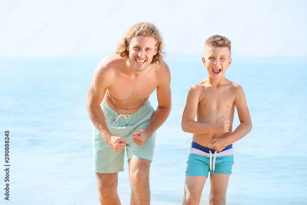 Happy man with little son on sea beach Happy man with little son on sea beach