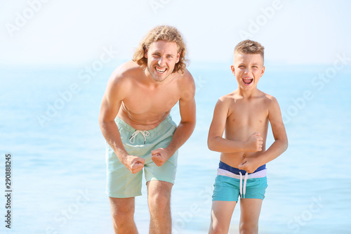 Happy man with little son on sea beach