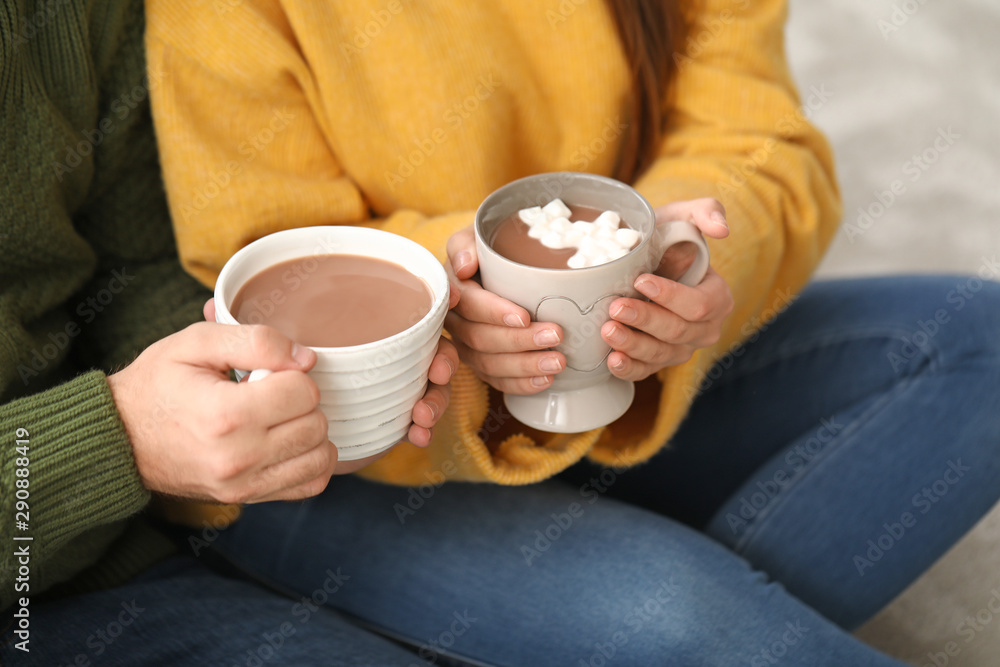 Young couple drinking hot chocolate at home, closeup Young couple drinking hot chocolate at home, closeup