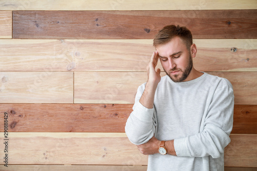 Stressed young man on woode...