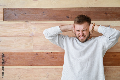 Stressed young man on woode...
