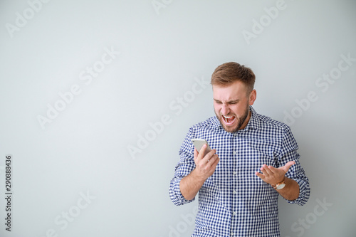 Stressed young man with mob...