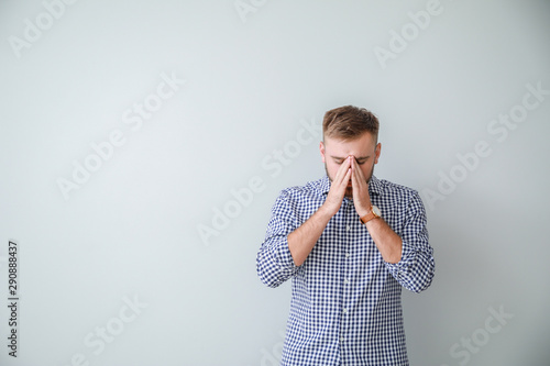 Stressed young man on light...