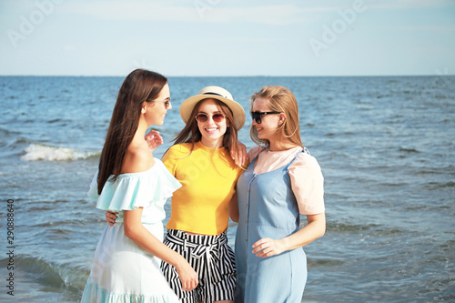 Happy young women on sea be...