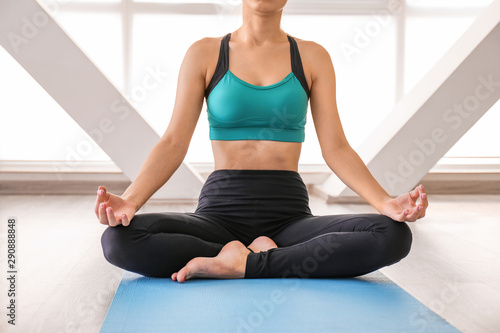 Young woman practicing yoga in gym