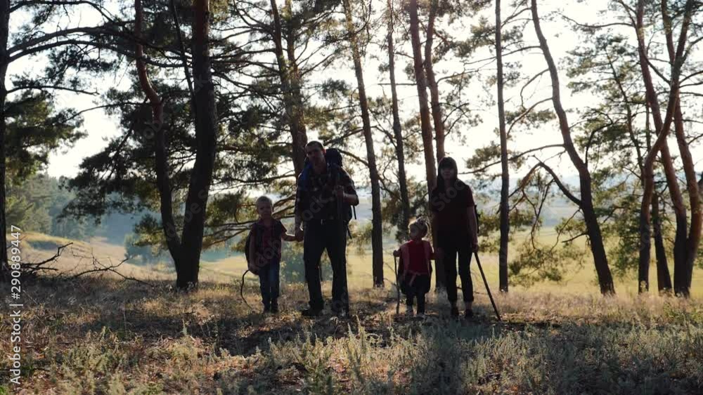 A happy family. Family travel and hiking through the forests at sunset. Walking in the open air, teamwork. Healthy lifestyle concept A happy family. Family travel and hiking through the forests at sunset. Walking in the open air, teamwork. Healthy lifestyle concept