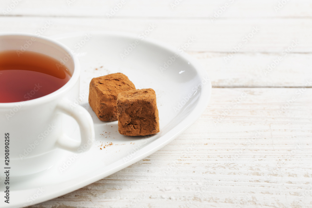 cup of tea with chocolate candy on wooden table cup of tea with chocolate candy on wooden table