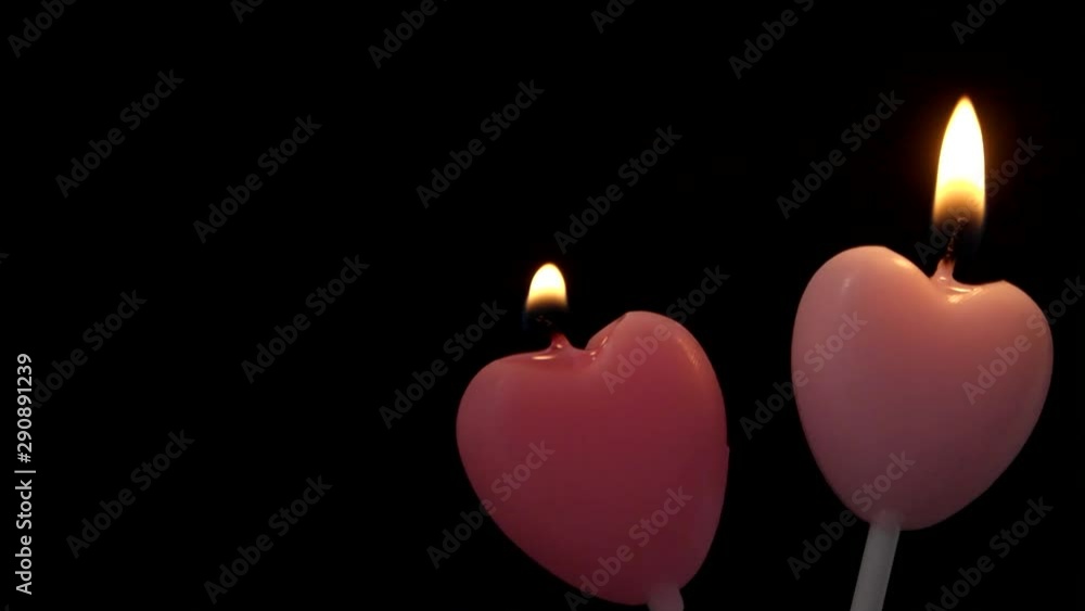 Two burning pink heart shaped candles on black background, can be used as lesbian love concept.