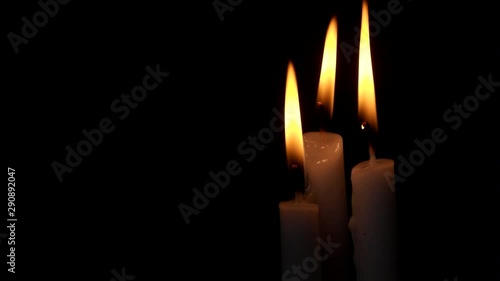 Burning and melting candles on black with room for text. Religion, funeral and memorial concept.