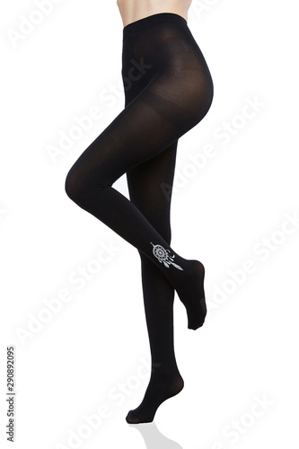 Cropped bottom shot of a female figure in black fantasy tights with white tattoo pattern. The fashion model bent one of her knees. 
