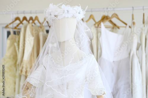 Wedding white gown for bride hanged in costume showroom for marriage or wedding reception. White delicated lace on long dress for promp or party © soultkd