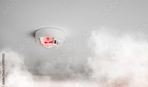 close-up of smoke alarm or smoke detector in home going off with thick smoke photo