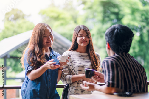 Closeup image of three people enjoyed talking and drinking coffee together in cafe