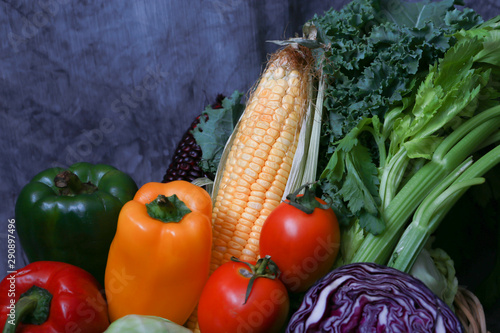 Fresh vegetable preparation for making food. There are lettuce  green parsley  sweet conn  tamoto  cabbage  bell chili on rattan basket with rustic cloth as background