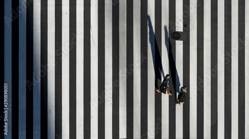 Aerial view of people passing crosswalk in the downtown street.