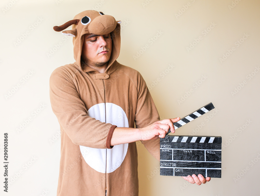 Man in cosplay costume holding black clapperboard. Guy in the funny animal  pyjamas sleepwear making a film. Directing and of amateur cinema movie.  Creative concept. Japanese anime. Stock Photo | Adobe Stock