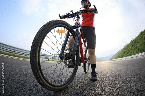 Woman cyclist riding mountain bike on highway