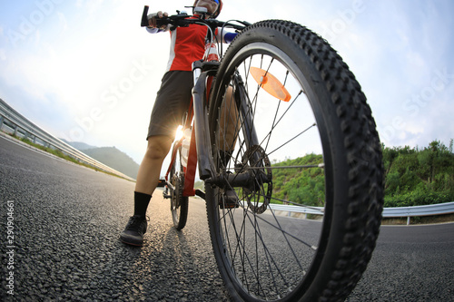 Fototapeta Naklejka Na Ścianę i Meble -  Woman cyclist riding mountain bike on highway