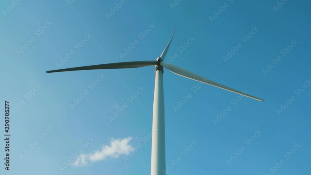Low angle shot of a windmill against the clear blue sky. Green Energy Low angle shot of a windmill against the clear blue sky. Green Energy