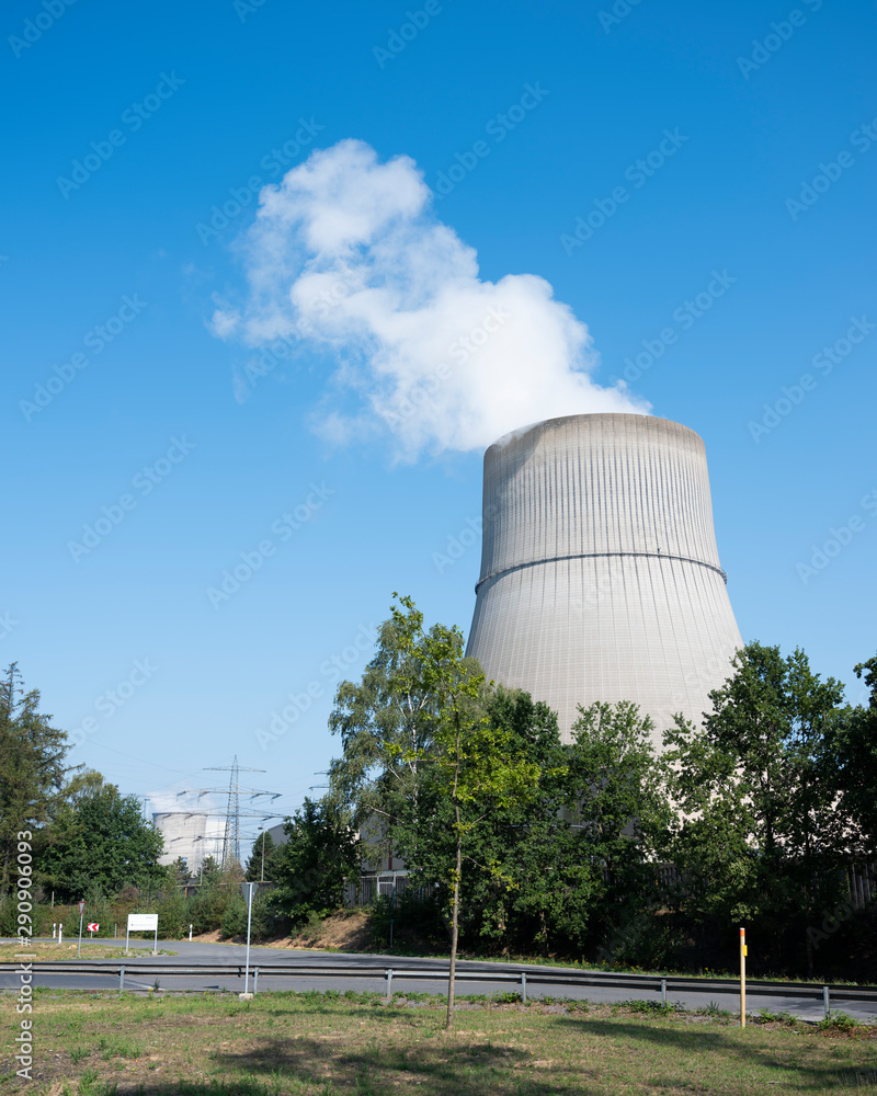 steam and blue sky above large chimney of nuclear power plant near lingen in lower saxony