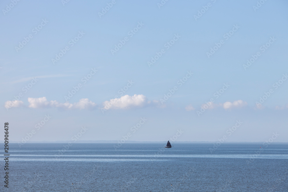 lonely sailing vessel on blue water of wadden sea in the netherlands