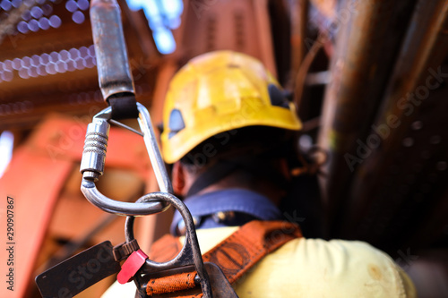 Quadro em tela Construction worker welder wearing safety helmet, fall arrest harness clipping l