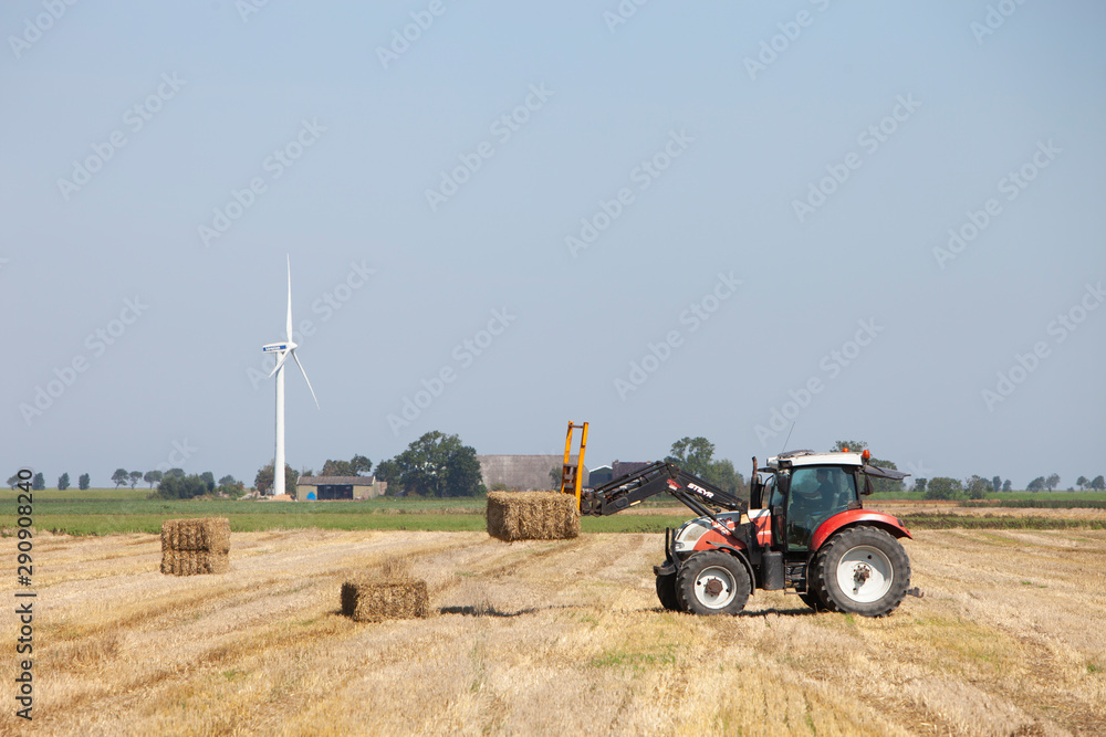 Φωτογραφία farmer in tractor busy collecting hay bales with tractor in dutch province of gr