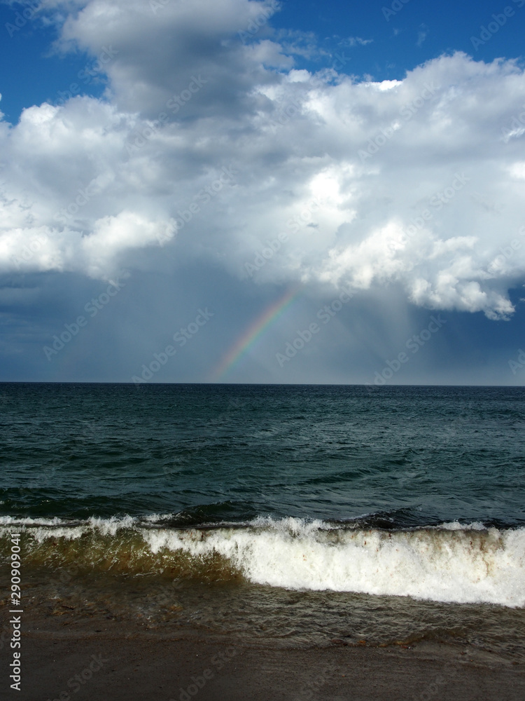 Regenbogen über dem Meer: Aufziehende Regenwolke