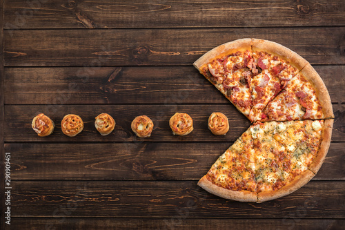 Pizza eating Pepperoni Rolls on a dark brown wooden background. Copy space, top view of pieces pizza and flat lay concept