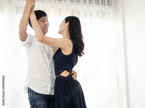 Asian couple dancing together at home, lifestyle concept.