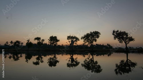 Timelapse morning ray over the tree in the water at Bukit Mertajam, Penang. photo